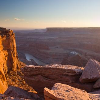 This was taken at dead horse point looking south into Canyonlands national park.  The Colorado river can be seen below winding around a canyon it carved.  This was just shortly before sunset, and you can see some haze in the distance - evidence of the high speed winds picking up lots of dust.  We had some shelter sitting behind a small rock wall but it was quite windy.  